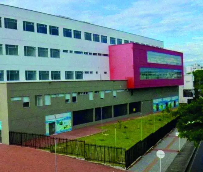 Hospital con fachada blanca y volumen rojo